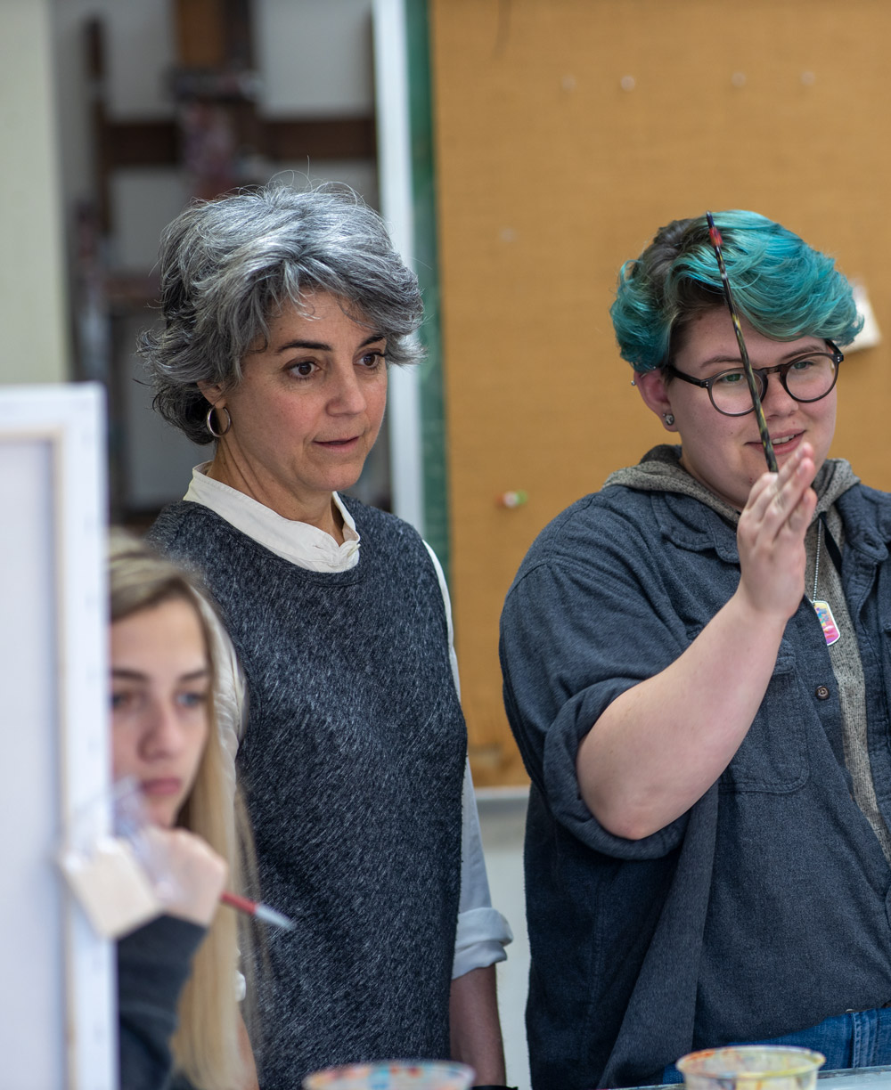 Art and Design professor works with students during a painting class.