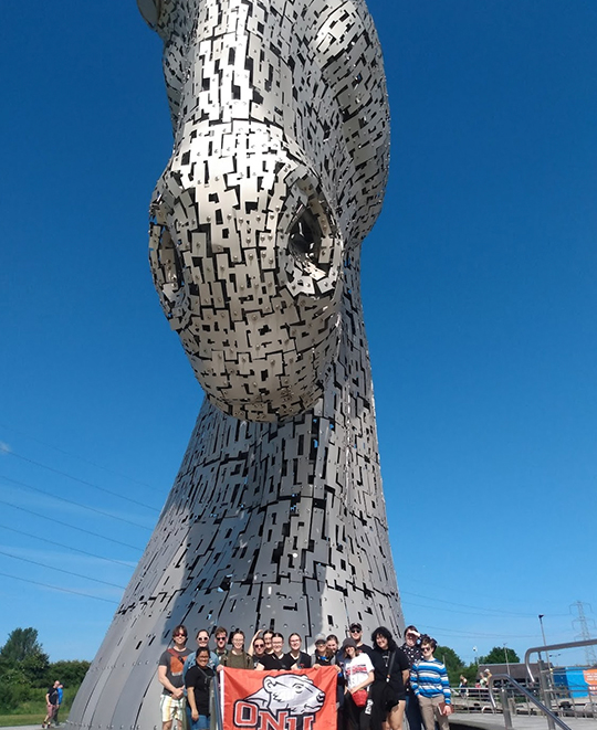 Photo of the ONU group posing in front of a giant metal horse head sculpture