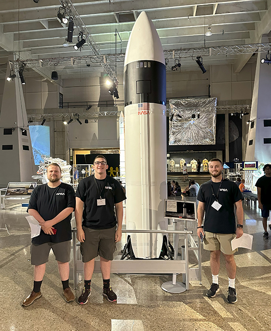 Photo of ONU students in front of a rocket on display