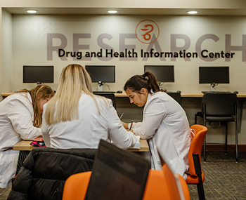 Photo of Pharmacy students seated at a table studying