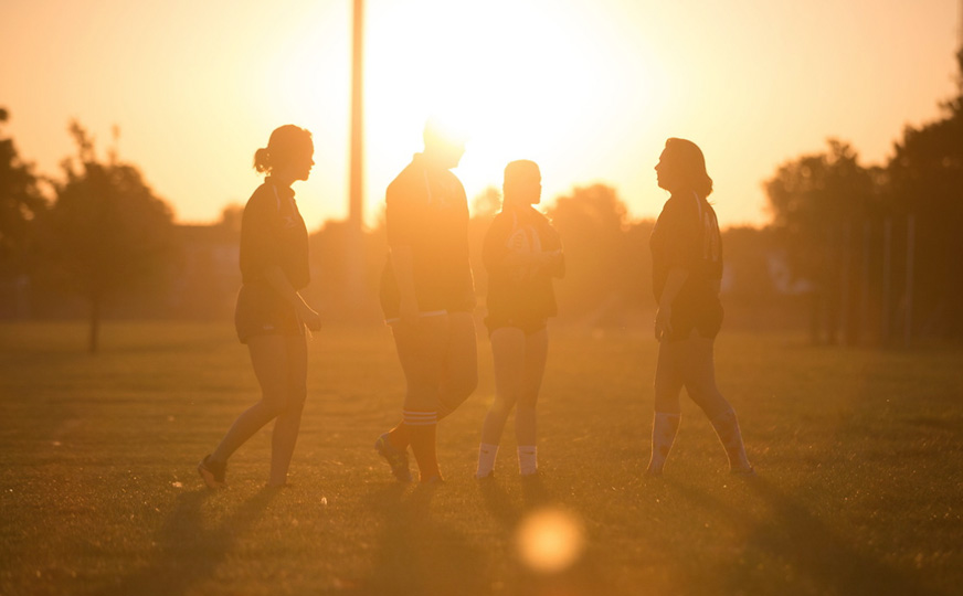 Photo of Student shadows with the sun setting really bright behind them