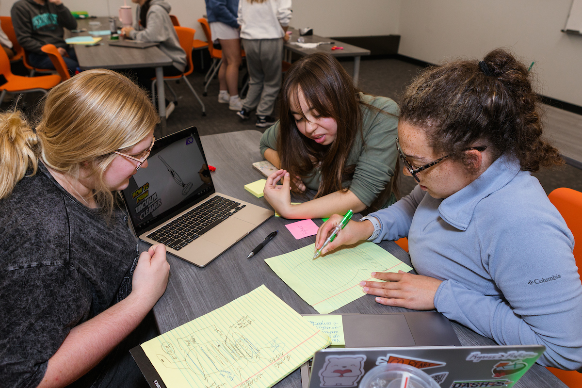 students working on a project with a laptop