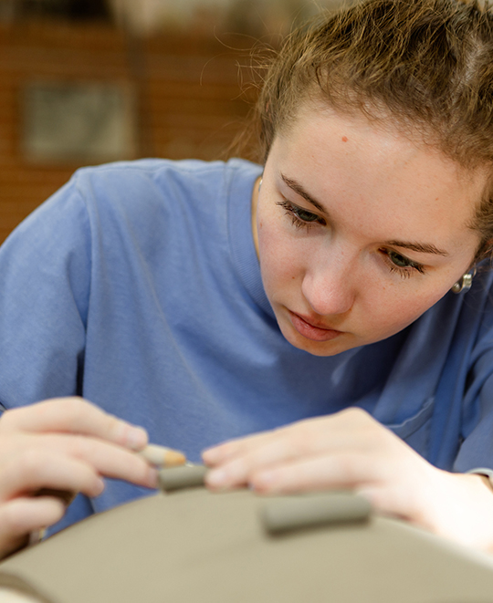 Photo of Art and Design class, ONU student working on a clay slab