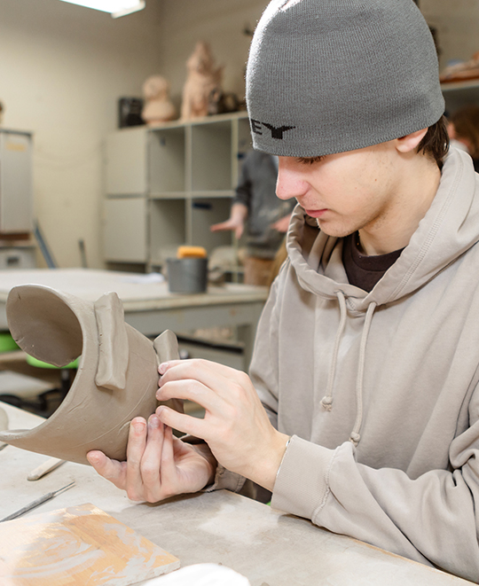 Photo of Art and Design class, ONU student working on his clay project