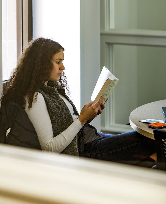 Photo of an ONU student in a quiet space reading a book