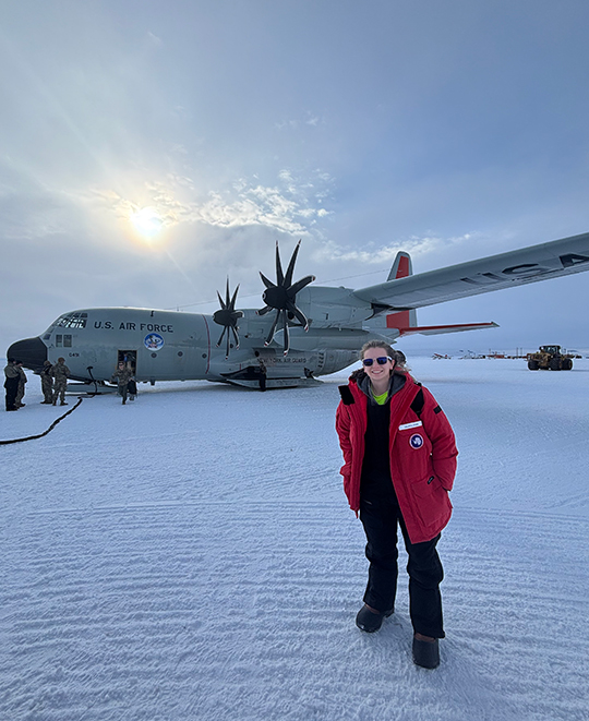 Photo of Lauren with a side view of an airplane behind her