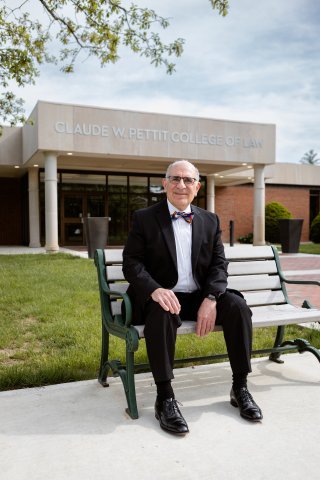 Photo of Mort sitting in front of the Law Building