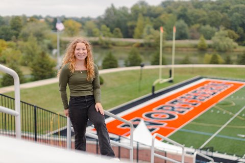 Photo of Jayanti posing in front of football field