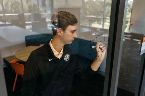 Photo of Peyton writing on a glass like a chalkboard