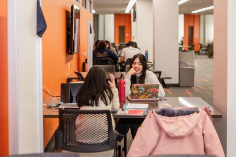 Photo of ONU students at a table conversing and studying.