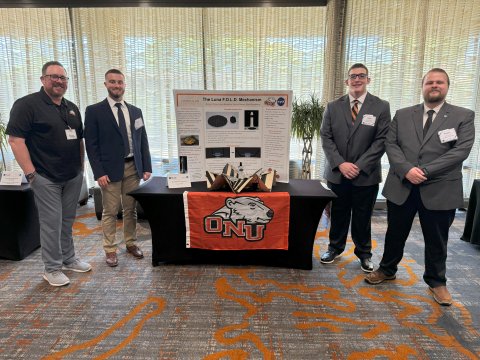 Photo of ONU students in front of their poster display