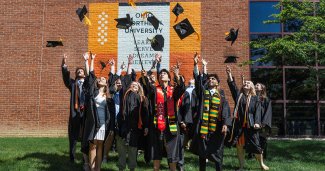 Photo of many ONU students tossing their graduation caps into the air.