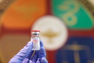 An Ohio Northern University student holds up a vial of Moderna COVID-19 vaccine.