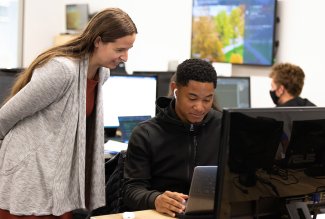 Professor Coffman-Wolph helping a student behind a laptop